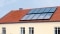 Na obrázku jsou vidět solární panely na střeše jako záložní zdroj vytápění.
